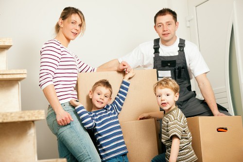 Removal crew transporting office desks and chairs in a local business move